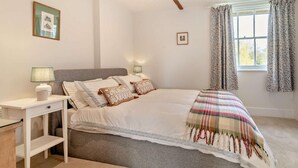 A bedroom with a bed, bedside tables, a window with curtains, and wall-mounted pictures. - 1 Bed in Sherborne (oc-94306) (Chetnole)
