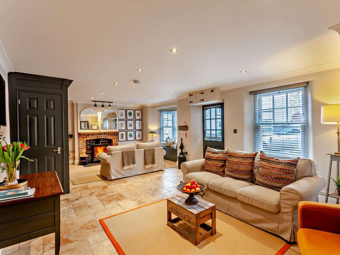 A living room with a fireplace, a sofa, a coffee table, and a door.