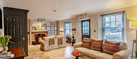 A living room with a fireplace, a sofa, a coffee table, and a door.