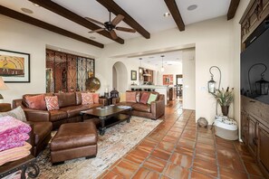 A spacious living room with leather sofas, a coffee table, and a fireplace. - Saltwater Pool/Spa, Tanning Shelf, Firepit, Outdoor Fireplace Shower Free WiFi (Palm Springs)