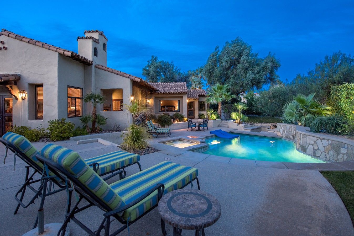 A house with a swimming pool, outdoor seating, and a patio area.