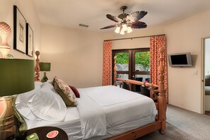 A bedroom with a bed, a ceiling fan, a TV, and a window with curtains. - Outdoor Shower, Swim-Up Wetbar, Hot Tub, Putting Area, Firepit, EV Charger (Palm Springs)