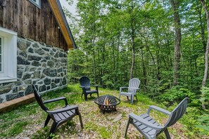 A stone building with a fire pit and outdoor seating. - Two Cottages w/ Private Setting | Killington Views (Strafford)