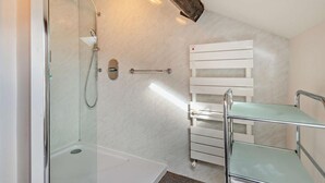 A modern bathroom with a glass shower enclosure, a white towel rack, and a glass shelf. - 3 Bed in Keswick (oc-94346) (Threlkeld)