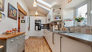 A modern kitchen with a skylight, built-in oven, and a large window. - 3 Bed in Keswick (oc-94346) (Threlkeld)
