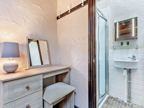 A bathroom with a white sink, a glass shower enclosure, a wooden vanity with drawers, a bench, and a mirror with a wooden frame. - 2 Bed in Bassenthwaite (oc-83287) (Bassenthwaite)