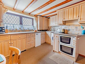 A kitchen with wooden cabinets, a dishwasher, a double oven, and a window with a view. - 3 Bed in Matlock (oc-pk933) (Hackney)
