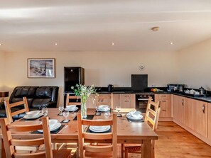 A dining area with a wooden table set for four, a black refrigerator, a microwave, and a coffee maker on the counter. - 3 Bed in Bishop Auckland (oc-94320) (Wolsingham)