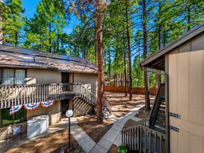 A residential property with a two-story building, a covered outdoor area, and a wooden fence. - 2BR mountain condo w fireplace, board games! (Pinetop)