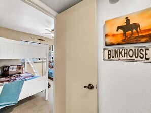A bunk bed room with a door labeled 'BUNKHOUSE.'