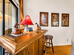 Eine Holztresore mit roter Lampe, einer Pferdefigur und gerahmten Postern an der Wand.