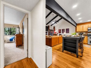 A modern kitchen with wooden cabinets, a central island, and a dining area.