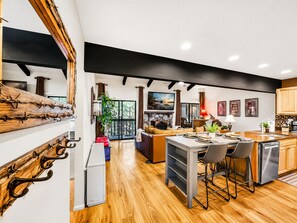 A modern kitchen with a central island, wooden flooring, and a black ceiling beam. - 2BR mountain condo w fireplace, board games! (Pinetop)