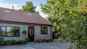 A two-story house with a tiled roof, a front door, and a gravel driveway. - 1 Bed in Bridgwater (oc-79215) (Ashcott)