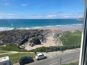 A coastal road with a 'KEEP CLEAR' marking, a rocky beach, and the ocean in the background. - 1 Bed in Woolacombe (oc-76348) (Woolacombe)