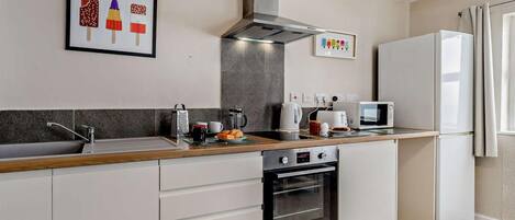 A modern kitchen with a built-in oven, a microwave, and a refrigerator.