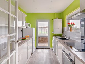 Una cucina moderna con mobili bianchi, un forno a microonde e un lavello.
