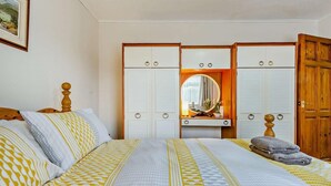 A bedroom with a bed, a vanity with a mirror, and a wardrobe. - 2 Bed in Jameston (oc-fb011) (Jameston)