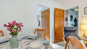 A dining area with a table set for two, a vase of flowers, and a chair. - 2 Bed in Jameston (oc-fb011) (Jameston)