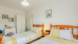 A double room with two beds, a bedside table with a lamp, a wardrobe, and a mirror. - 2 Bed in Jameston (oc-fb011) (Jameston)