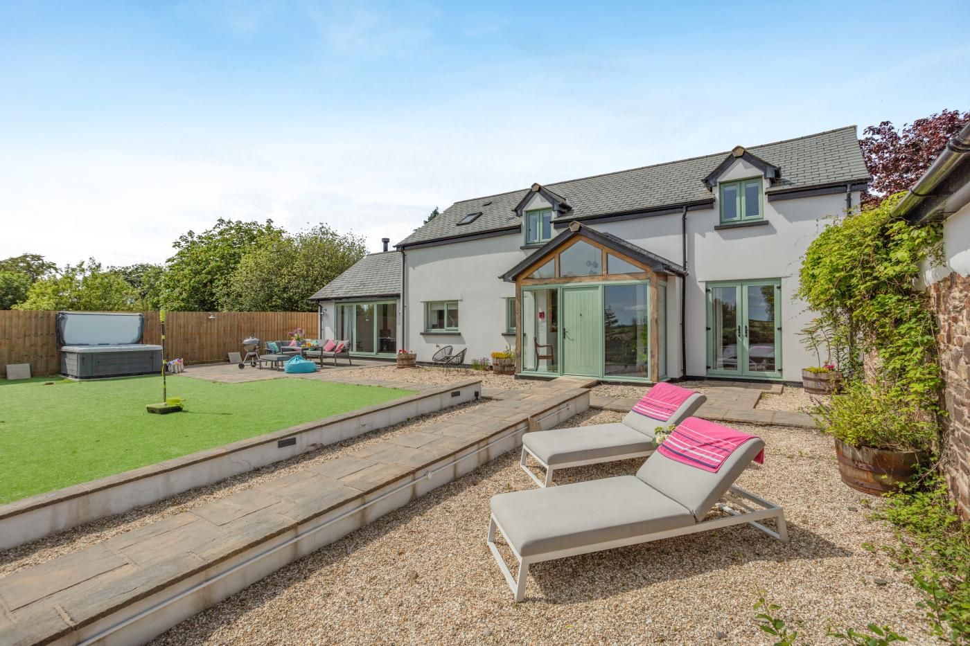 A house with a patio, a hot tub, and a garden.