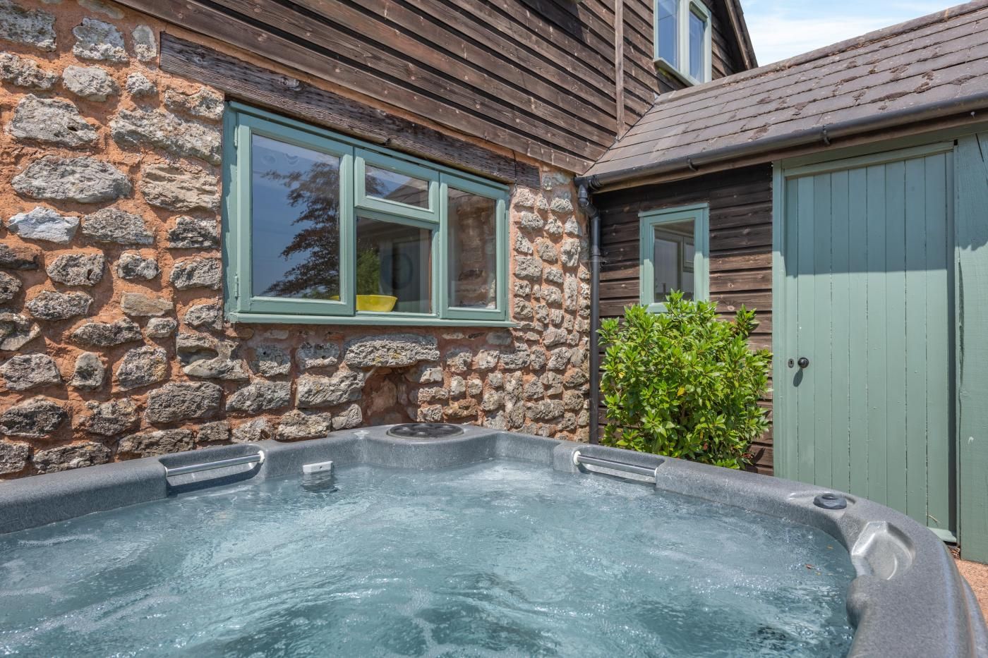 Un edificio de piedra con un jacuzzi en la parte frontal.