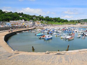 A harbor with boats docked, a stone wall, and buildings in the background. - 4 Bed in Honiton (oc-41045) (Sheldon)