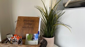 A wicker basket with a wooden sign, a potted plant, and a small decorative item on a table.