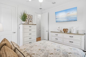 A bedroom with a bed, dresser, and a painting on the wall. - Serenity Seas - All New Luxury Home Across from Beach w/ Heated Pool, Mini Golf (Indian Rocks Beach)