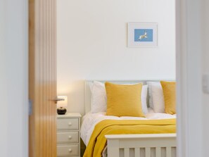 A bedroom with a bed, a bedside table, a lamp, and a framed picture on the wall. - 4 Bed in Bude (oc-66706) (Bude)