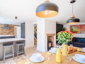 A modern kitchen with a central island, bar stools, and pendant lighting. - 4 Bed in Bude (oc-66706) (Bude)
