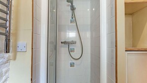 A glass-enclosed shower with a handheld showerhead and a handheld hose, a white bathtub, and a towel rack on the wall. - 1 Bed in Bideford (oc-pwork) (Buckland Brewer)
