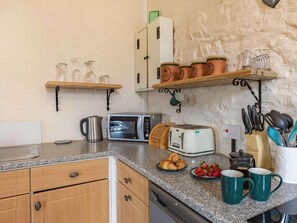 Eine Küche mit Mikrowelle, Toaster und verschiedenen Küchenutensilien auf der Arbeitsfläche.