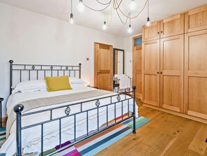 A bedroom with a bed, wooden wardrobe, and a mirror. - 2 Bed in Ulverston (oc-91730) (Blawith)