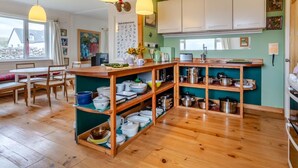 A kitchen with wooden shelves, white cabinets, and pendant lights. - 4 Bed in Ullapool (oc-ca278) (Achiltibuie)