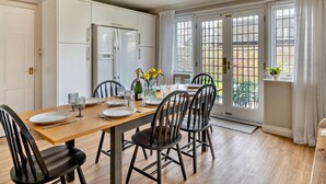 A dining area with a wooden table, four chairs, and a refrigerator. - 4 Bed in Carlisle (oc-94398) (Crosby-on-Eden)