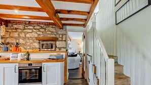 A kitchen with stone walls, wooden beams, a built-in oven, and a microwave. - 2 Bed in Lancaster (oc-91411) (Clapham)