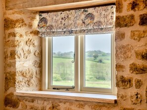 A window with a floral valance and a view of a green landscape. - 2 Bed in Stoke Abbott (oc-94406) (Stoke Abbott)