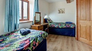 A bedroom with two beds, a window with curtains, a wooden wardrobe, and a painting on the wall. - 3 Bed in Ellesmere (oc-94419) (Dudleston)