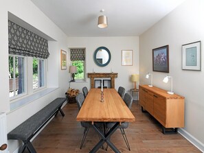 A dining room with a wooden table, grey upholstered chairs, a bench, a fireplace, and a wooden cabinet. - 2 Bed in Lockerbie (oc-94304) (Hoddom)