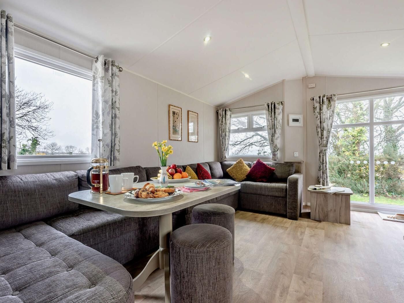Een moderne woonkamer met een bank, een salontafel en uitzicht op de omgeving.