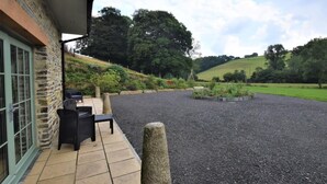 A building with stone walls and a patio area with outdoor seating. - 1 Bed in Launceston (oc-86675) (South Petherwin)