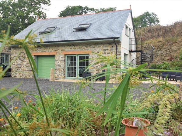 A stone building with a grey roof, a green door, and a spiral staircase. - 1 Bed in Launceston (oc-86675) (South Petherwin)