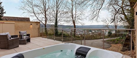 Un jacuzzi con vista a un pueblo y árboles.