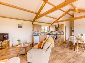 A spacious living area with a sofa, a dining table, and a kitchen in the background. - 2 Bed in Bideford (oc-76507) (Bideford)