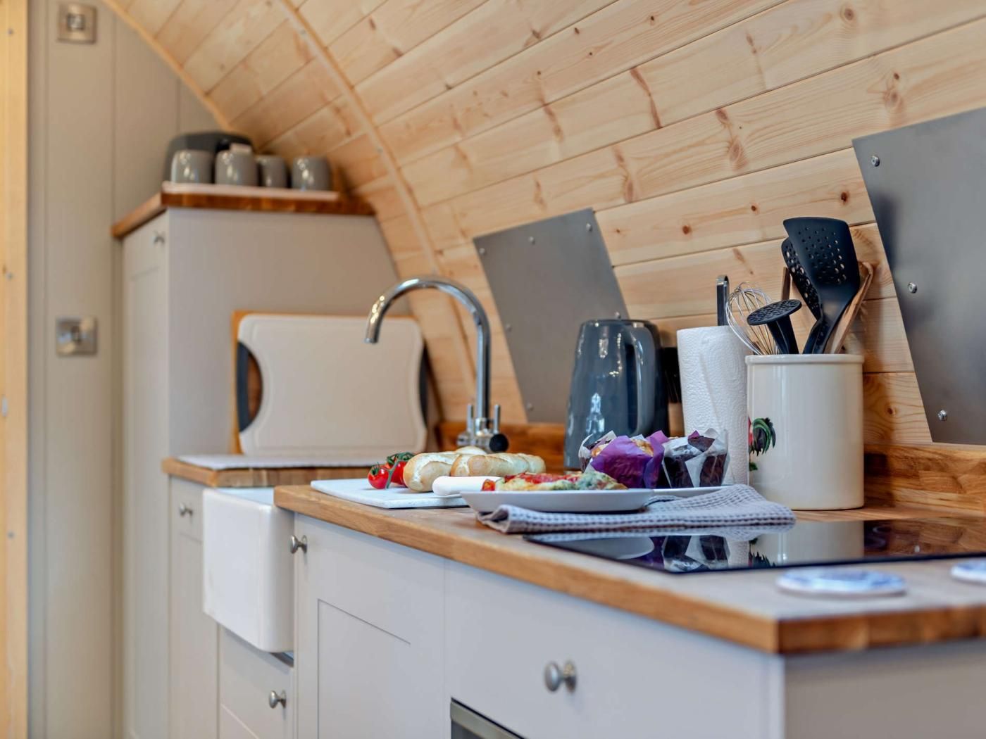 Une cuisine avec un plafond en bois, un évier, un grille-pain et divers ustensiles de cuisine.