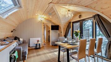 Un intérieur de chalet chaleureux comprenant un coin repas, une cuisine et un espace de vie.