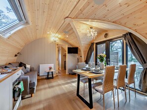 Un intérieur de chalet chaleureux comprenant un coin repas, une cuisine et un espace de vie.