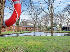 Une vue sur le fleuve, avec un bouée de sauvetage rouge, un bâtiment en briques et une structure couverte.