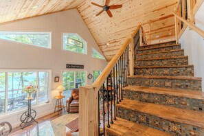 A wooden staircase with a decorative tile design, leading to a second floor. - Huckleberry: Sleeps 4: Directly on Lake Michigan! (Manistique)